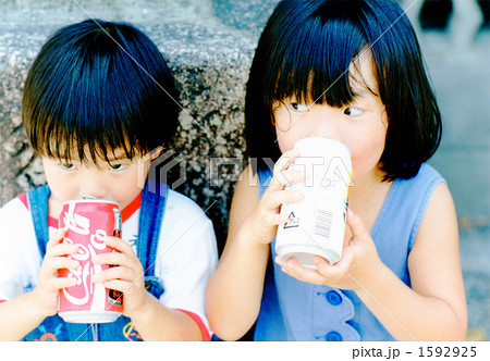 人物 飲む 姉妹 缶ジュースの写真素材