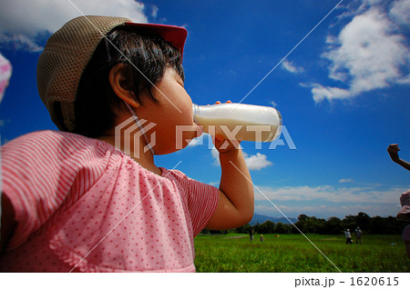 女の子 牛乳 一気飲み 青空の写真素材