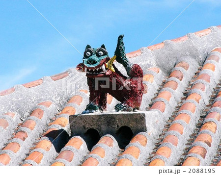 沖縄の家の屋根の上のシーサーの写真素材