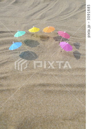 パラソル ミニチュア ビーチパラソル カラフル 波 砂 砂浜の写真素材