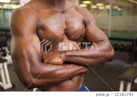 Portrait of shirtless muscular man standing with arms crossed