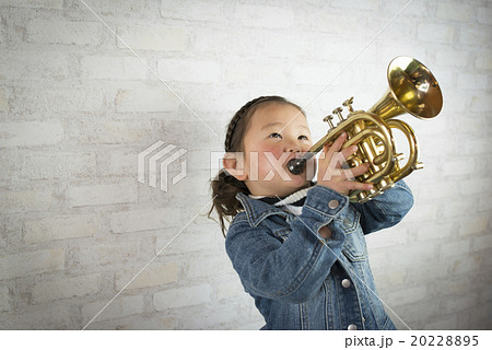子供 吹く トランペット 女の子の写真素材