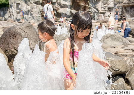 子供 水遊び 女の子 裸 笑顔 水の写真素材