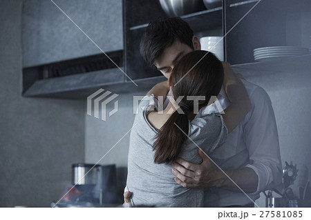 キッチン カップル 抱き合う キスの写真素材