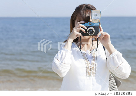 女性 覗く 構える カメラの写真素材