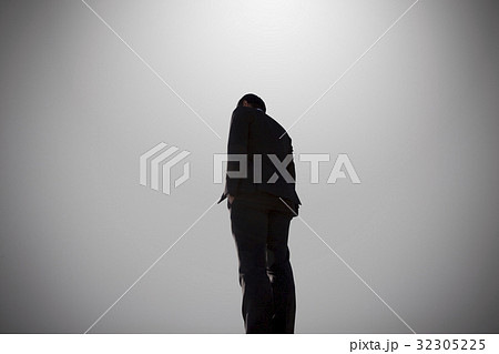 男性 ビジネスマン 立ち止まる 立ち尽くすの写真素材