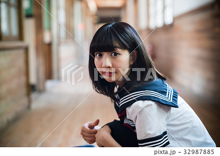 女子高生 木造校舎 廊下 しゃがむの写真素材