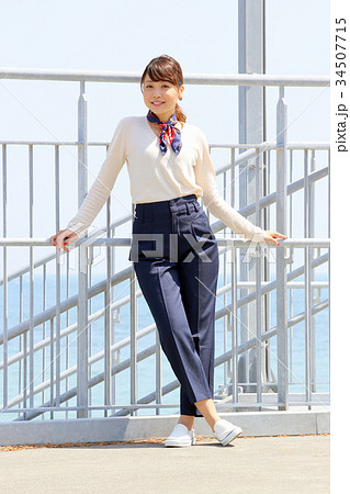 女性 ポーズ 海 フェンスの写真素材
