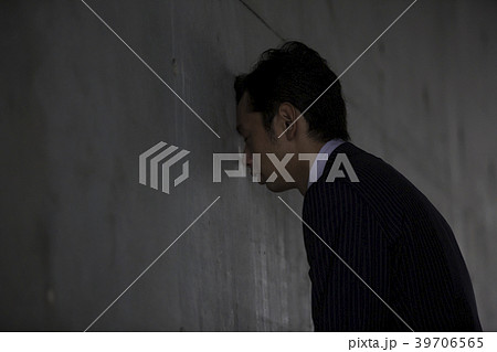 壁に頭をつけるの写真素材