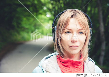 女性 女の子 ヘッドフォン パーカー 音楽の写真素材