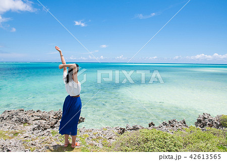 女性 後姿 全身 ワンピース 日本人 青空 砂浜 海の写真素材