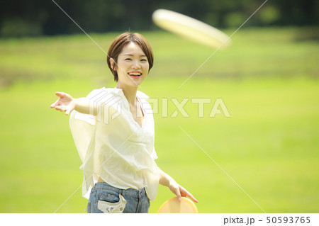 フリスビー 女性 人物 芝生の写真素材