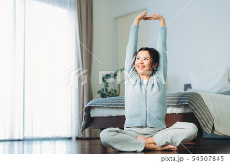 人物 女性 寝起き 伸び ポーズの写真素材