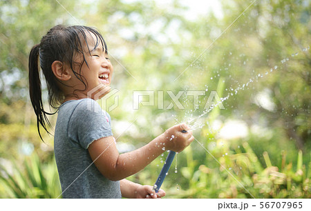 子供 女の子 水遊び ホースの写真素材