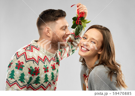 クリスマス カップル キス ヤドリギの写真素材