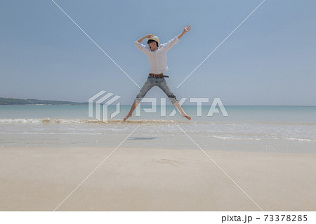 帽子を押さえる 帽子の写真素材