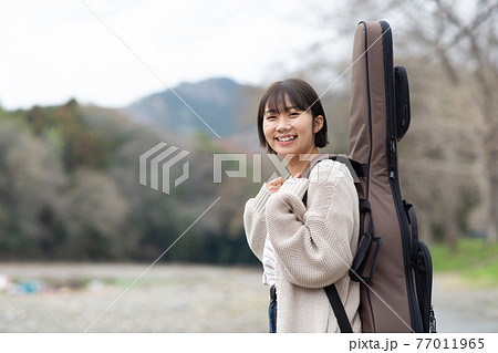 人物 女性 ギター 背負うの写真素材
